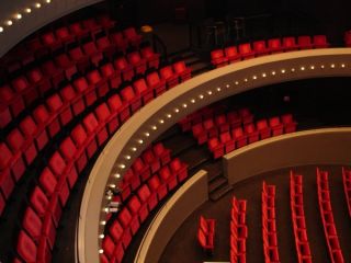 Rode theaterstoelen in halve cirkel op balkon theater